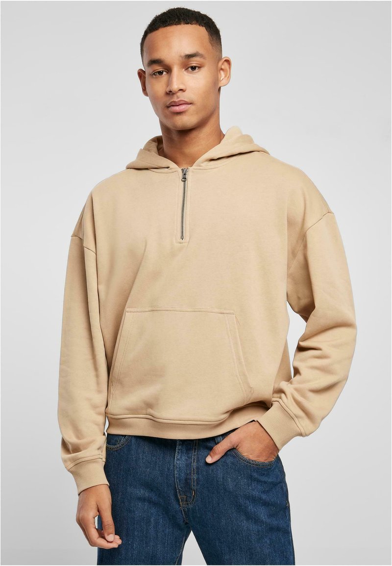 Felpa con zip beige, dotata di una tasca frontale, caratterizzata da una vestibilità comoda e polsini a coste. Realizzata in morbido tessuto misto cotone.