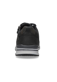 Schwarzer Sportschuh mit einer glatten Leder- und Mesh-Oberfläche, rückseitigem Reißverschluss, dezent strukturierten Akzenten und einer weißen Zwischensohle.