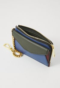 Portefeuille multicolore en cuir texturé de couleur verte, bleue et bordeaux. Il est doté d'une chaîne dorée, d'une fermeture éclair et d'une poche avant.