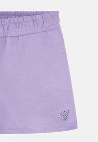Violetas šortus ar elastīgu jostasvietu, izgatavotus no mīksta auduma. Apakšējā labajā stūrī ir mazs sudraba rhinestone logo.
