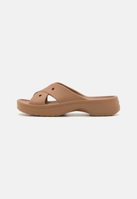 Sandales en cuir tan avec une base moulée incurvée, présentant un design à bout ouvert, deux lanières supérieures croisées et des trous de ventilation pour la respirabilité.