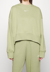 Ljusgrön croppad sweatshirt i mjukt material, med rund halsringning och långa ärmar. Vit Nike-logga på bröstet.