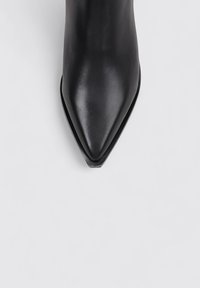 Pointed-toe black leather ankle boot with a smooth texture and sleek silhouette. Features a flat, rounded sole and subtle stitching detail.
