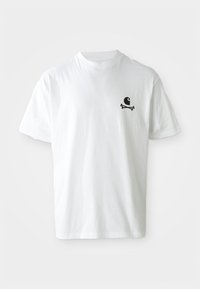 Camiseta blanca de manga corta con un pequeño gráfico negro de un ojo estilizado sobre huesos cruzados en el lado izquierdo del pecho.