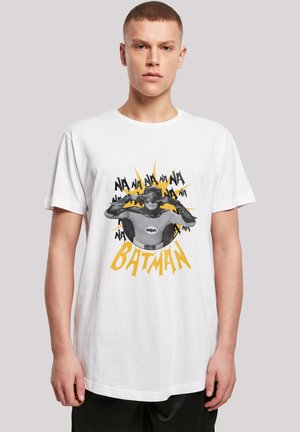 White cotton t-shirt featuring a graphic print of Batman with "NA NA NA" text in black and yellow burst design, short sleeves, and crew neck.
