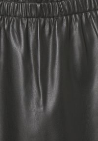 Gonna di pelle nera con una texture liscia e una cintura elastica arricciata, che mette in evidenza pieghe sottili e un profilo elegante.