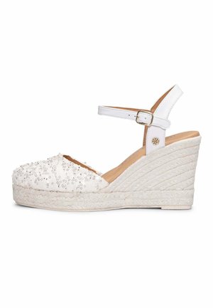 Sandalia espadrille blanca con cuña, tiras en el tobillo, puntera adornada con lentejuelas, suela plataforma trenzada y cierre de hebilla.