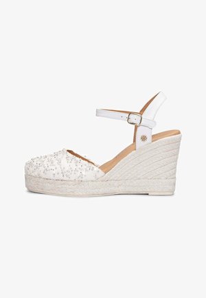 Sandalia espadrille blanca con cuña, tiras en el tobillo, puntera adornada con lentejuelas, suela plataforma trenzada y cierre de hebilla.