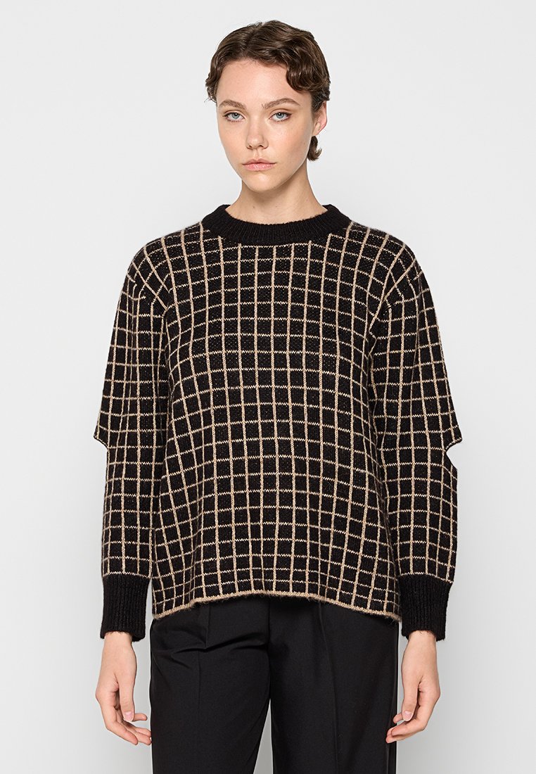 Schwarz-beige kariertes Strickpullover mit Rundhalsausschnitt, überschnittenen Schultern und gerippten Bündchen. Der Stoff wirkt weich und strukturiert.