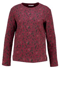 Rød langærmet sweatshirt med en tekstureret overflade og et sort bladmønster. Ribbet rundhals og tætsiddende manchetter.