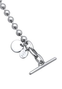 Collier en argent avec des perles sphériques, fermeture à bascule et deux médailles rondes, l'une estampillée "925" indiquant de l'argent sterling. Texture lisse et polie.