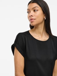 Haut noir à manches courtes avec une texture lisse et mate, un col rond et des poignets roulés. Design simple, style ajusté, tissu léger.