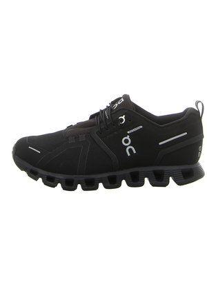 Black athletic shoes with waterproof fabric, minimalistic design, rounded toe, lace-up closure, and distinct hollowed-out sole for flexibility.