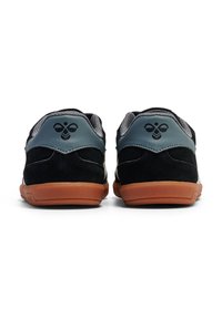 Svarta och grå sneakers med ett texturerat mockaöverdel, gummisula och en logotyp på hälen. Vadderad krage och meshfoder för komfort.