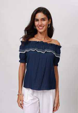Navy blue off-the-shoulder top with ruffled neckline and white embroidered accents. Soft fabric, short puff sleeves, relaxed fit.