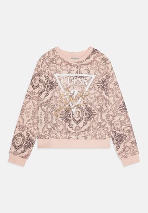 Sweatshirt rose avec un motif brun orné, logo "GUESS" en blanc et en accents dorés, poignets et ourlet côtelés, design col rond.