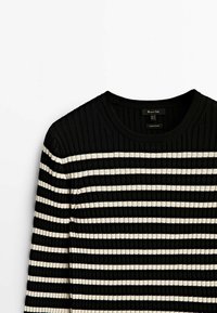 Pull noir à côtes avec manches longues, rayures blanches horizontales et col rond, posé à plat sur un fond blanc.