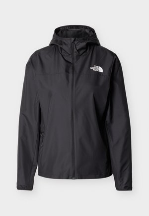 Svart lett hettejakke med frontglidelås og glidelåslomme på siden, med hvit The North Face-logo på brystet.