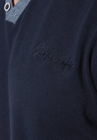 Dunkelblaues, gestricktes Poloshirt aus strukturiertem Stoff, mit einem kragen in Jeansfarbe und gesticktem Logodetail auf der Brust.