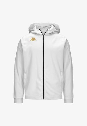 Veste à capuche blanche avec une fermeture éclair noire, arborant le logo doré de Kappa sur la poitrine et une manche. Tissu lisse avec poches latérales.