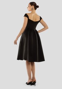 Zwarte A-lijn jurk met een getailleerd lijfje, off-shoulder mouwen en een rok die tot halverwege de kuit komt met plooien. Glad stof en verborgen rits.