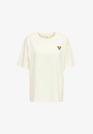 Kremfarget oversized t-skjorte laget av myk bomull, med en liten brodering av en teddybjørn på venstre bryst med en lilla sløyfe.