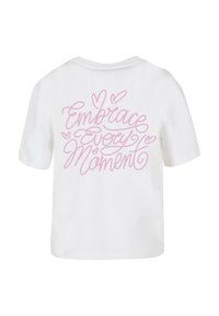 Vit bomull T-shirt med korta ärmar och avslappnad passform. På baksidan finns rosa kursiv text som läser "Omfamna varje ögonblick" med hjärtan som accenter.