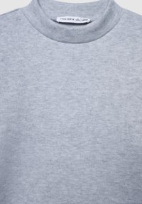 Jasnoszara bluza z okrągłym dekoltem. Wykonana z miękkiego materiału o textured wykończeniu. Widoczna metka marki przy dekolcie.