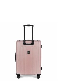 Valigia rigida di colore rosa metallizzato con scanalature verticali, maniglia retrattile nera e ruote lisce per una facile mobilità.