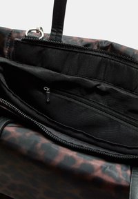 Černá taška přes rameno s leopardím potiskem, obsahující kapsu na zip uvnitř, měkkou podšívku a pevné uši.
