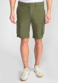 Shorts cargo vert olive avec fermeture à bouton, deux poches latérales et une coupe décontractée. Fabriqués en tissu léger, adaptés pour le port décontracté.