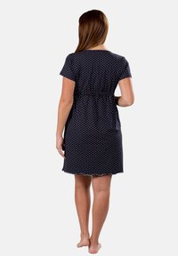 Vestito corto blu navy con pois bianchi, maniche corte, vita arricciata e orlo scallop, realizzato in tessuto leggero.