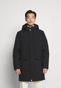 Svart vanntett parkas med hette, trykknapper og to frontlommer. Glatt tekstur og rett snitt for varme og dekning.