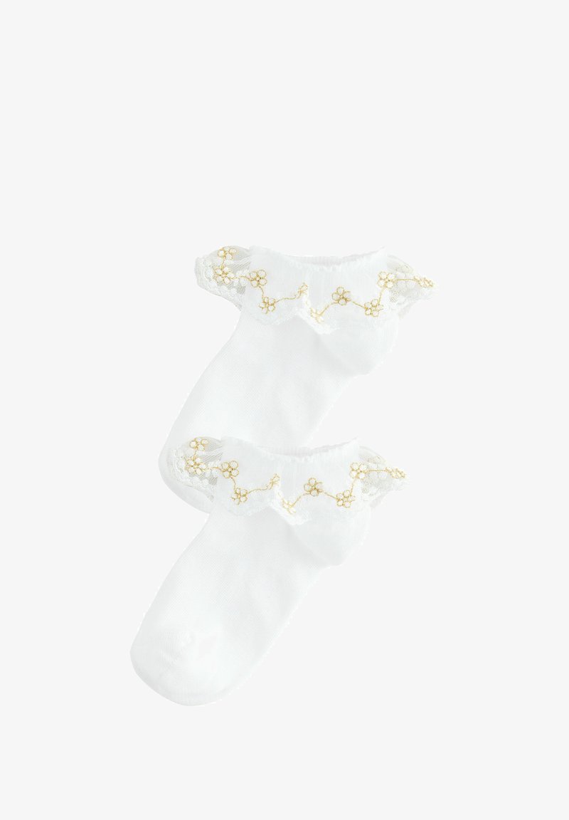 Chaussettes blanches en coton arrivant aux chevilles avec un revers en dentelle froncée et de petites fleurs dorées brodées le long du bord. Texture douce et design léger.