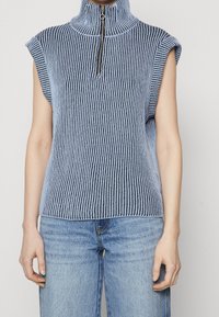 Ärmelloses Stricktop mit hohem Kragen und halbem Reißverschluss in vertikalen blauen und weißen Streifen. Hergestellt aus weichem, strukturiertem Stoff.