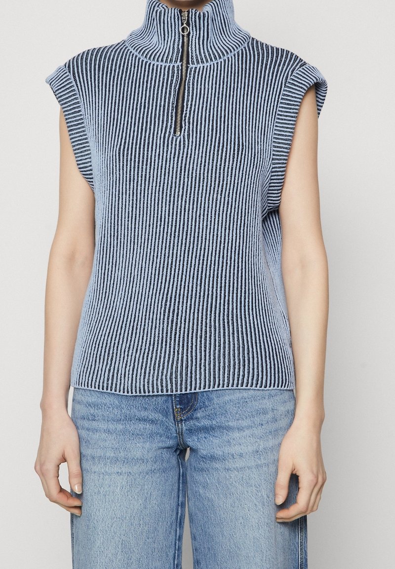 Ärmelloses Stricktop mit hohem Kragen und halbem Reißverschluss in vertikalen blauen und weißen Streifen. Hergestellt aus weichem, strukturiertem Stoff.