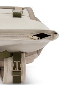  Bézs hátizsák cipzáras rekesszel, zöld pántokkal és texturált anyagokkal. Lapos sziluettel és tartós csattal rendelkezik.