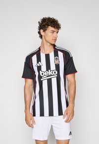 Mustvalge triibuline jalgpallimärkidega särk punaste detailidega. Sisaldab Adidas logo, sponsorinimi "beko" keskel trükituna ning lühikesed varrukad.