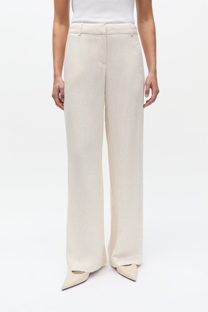 Heleduseeritud beežid laiade jalgadega püksid tekstuurse kangaga. Omadused: kitsendatud vöökoht, kahe eesmise taskuga ja volt mõlema säärme esiküljel.