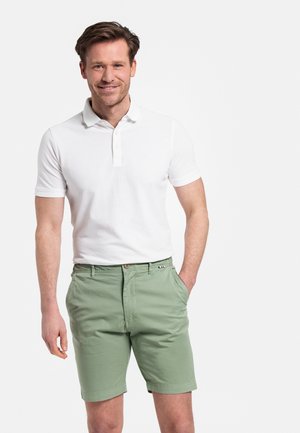 White polo shirt with short sleeves, paired with light green shorts featuring a button front and side pockets. Simple design and soft texture.