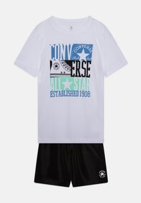 T-shirt en coton blanc avec un graphique "Converse" multicolore et un short noir avec logo. Manches courtes, col rond et coupe décontractée.