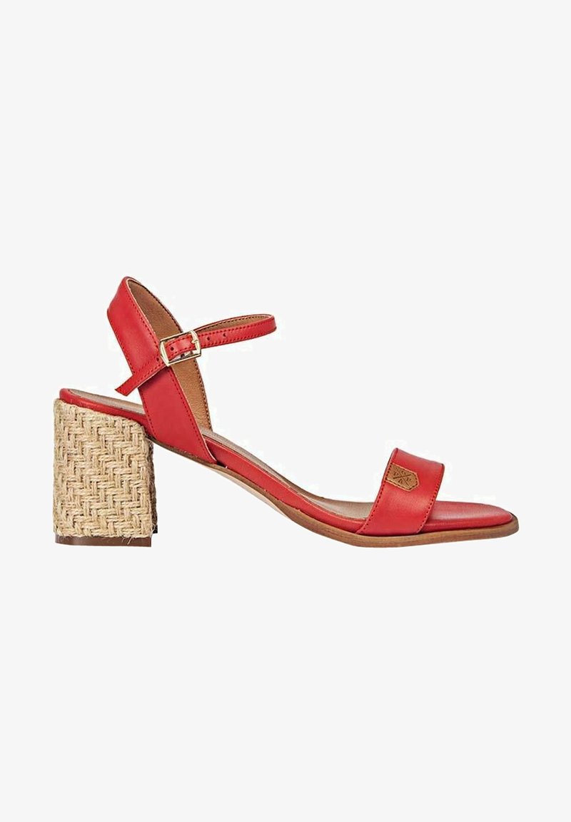 Sandale en cuir rouge avec bride à la cheville, bout ouvert et talon bloc tressé sur fond blanc.