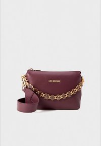 Burgundy Love Moschino bag with gold logo plaque and detachable chain strap spelling "Love Moschino" in stylized letters.