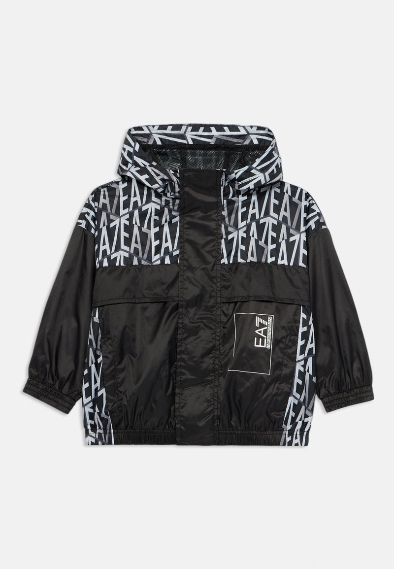 Μαύρο αδιάβροχο μπουφάν με κουκούλα, με γεωμετρικό μοτίβο και λογότυπο σε γκρι. Ελαστικές μανσέτες και μπροστινής τσέπης με καπάκι.