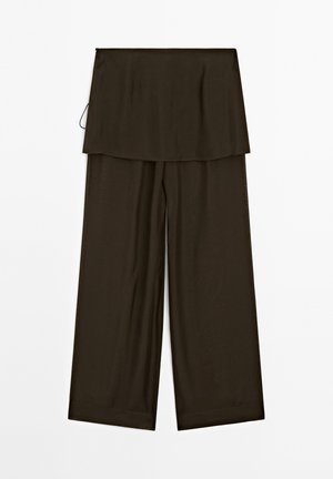Pantalons larges marron foncé avec une section supérieure fluide et superposée ; le tissu semble léger et doux sur un fond blanc.