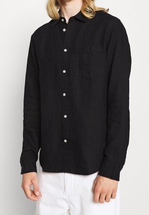 Zwarte langemouwshirt van lichtgewicht stof met een knoopsluiting aan de voorkant, één borstzak en knoopmanchetten.
