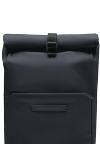Sac à dos roll-top en matériau bleu marine foncé, doté d'une finition texturée, d'une poche latérale et d'une fermeture à sangle noire en haut.