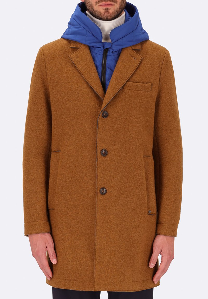 Cappotto in misto lana marrone con una vestibilità su misura, colletto a punta e chiusura con bottoni. Presenta un cappuccio trapuntato blu sottostante.