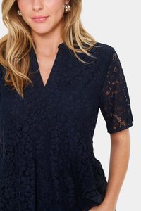 Tumedast sinine pitsist topp lühikeste varrukatega, millel on V-winaga ja lillemustrid. Pehme tekstuur ning peplum-disaini detailsus.