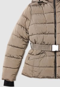 Giacca imbottita color khaki con cuciture orizzontali, vita elastica con dettaglio in fibbia e polsini neri. Caratterizzata da una zip frontale e tasche.